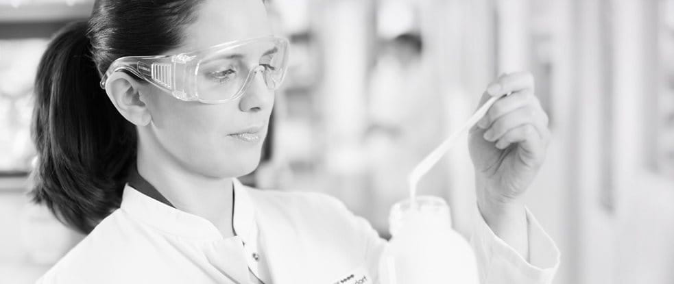 Científica con gafas protectoras analizando una fórmula