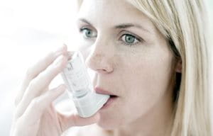 Mujer utilizando un inhalador.