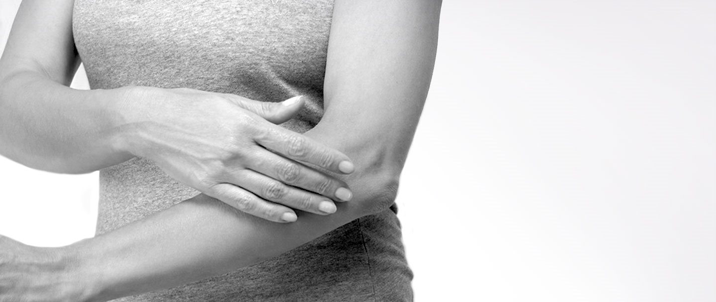 Mujer tocándose el brazo izquierdo